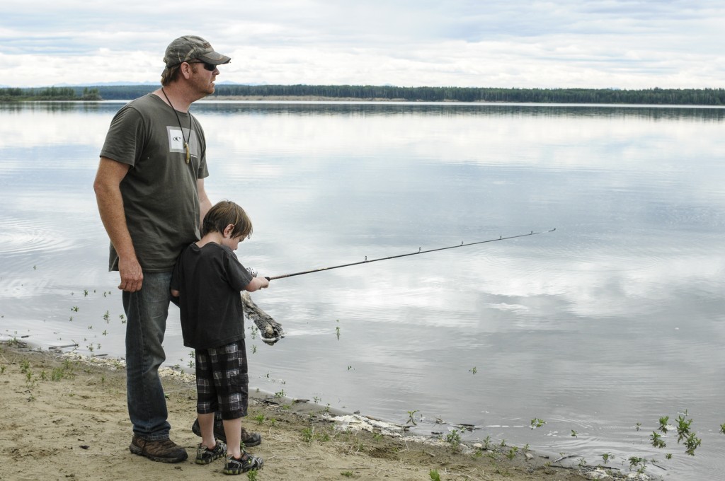 Dad teaching child to fish